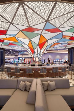 Centered within the vast gaming floor, a dazzling 40-foot diameter canopy of steel and colored resin serves as a centerpiece, floating above guests at the Prizm Lounge. Brightly colored, back-lit panels spring up from the center bar, serving as a beacon for guests and capturing the energy of the space. Centered within the vast gaming floor, a dazzling 40-foot diameter canopy of steel and colored resin serves as a centerpiece, floating above guests at the Prizm Lounge. Brightly colored, back-lit panels spring up from the center bar, serving as a beacon for guests and capturing the energy of the space.