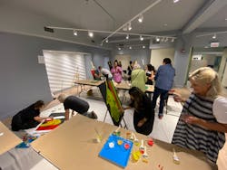 Attendees paired up in teams to paint original pieces of artwork during the Night of Giving to benefit local non-profit Designs for Dignity. Attendees paired up in teams to paint original pieces of artwork during the Night of Giving to benefit local non-profit Designs for Dignity.