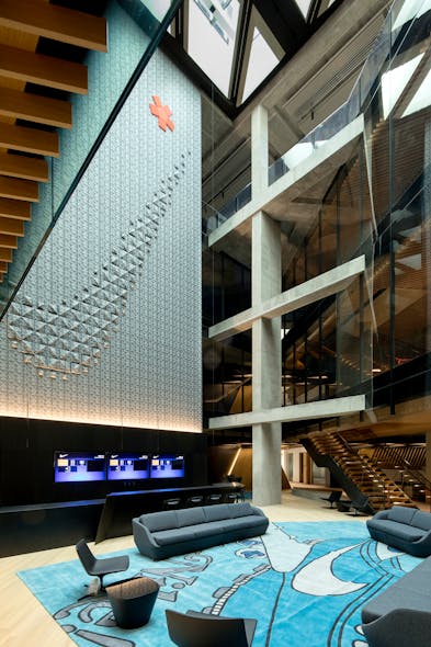 An atrium wall features a giant version of Nike&apos;s swoosh symbol. The asterisk ties back to founder Bill Bowerman&apos;s phrase, &apos;If you have a body, you are an athlete.&apos;