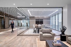 The entry area screams sophistication with a warm, neutral color palette and glass-enclosed conference room. TMA also utilized mirrors again in the corridor to further play with space volume. The entry area screams sophistication with a warm, neutral color palette and glass-enclosed conference room. TMA also utilized mirrors again in the corridor to further play with space volume.