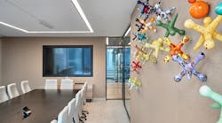 A vibrant wall sculpture featuring colorful, enlarged jacks that spill across the wall in a conference room keeping employees engaged and excited to interact.