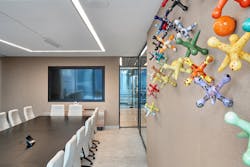 A vibrant wall sculpture featuring colorful, enlarged jacks that spill across the wall in a conference room keeping employees engaged and excited to interact. A vibrant wall sculpture featuring colorful, enlarged jacks that spill across the wall in a conference room keeping employees engaged and excited to interact.