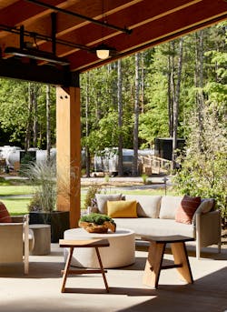 A covered patio extends the indoor and outdoor connections at the Catskills Clubhouse in New York. The communal space is outfitted with fire pits and seating, making it accessible for every season.