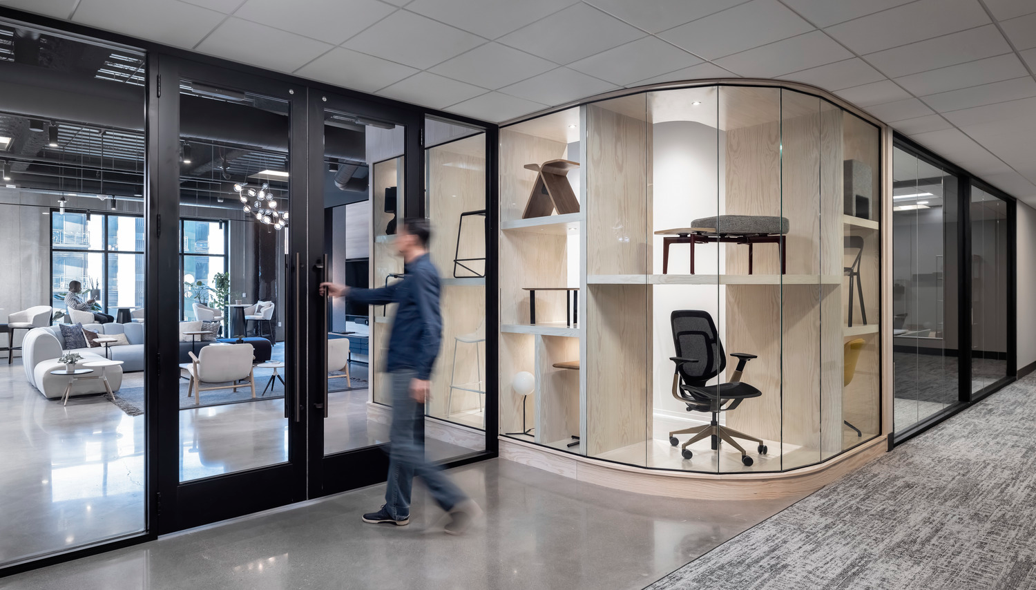 The new Acre office and showroom entrance features a curved glass product showcase framed by subtle colors to make the pieces the focal point.