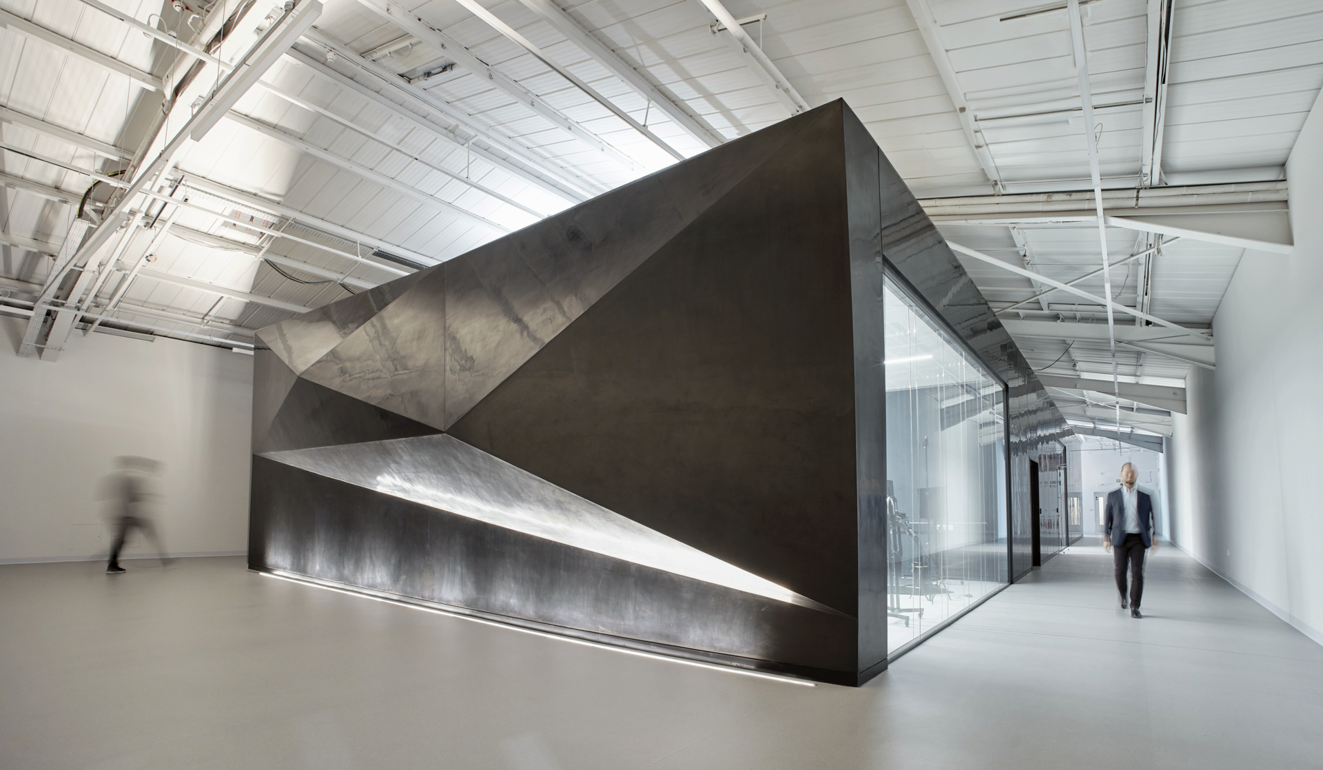 The XR Lab has a unique polished plaster exterior, including this feature wall with triangular mesh illuminated by uplighting.