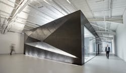 The XR Lab has a unique polished plaster exterior, including this feature wall with triangular mesh illuminated by uplighting. The XR Lab has a unique polished plaster exterior, including this feature wall with triangular mesh illuminated by uplighting.