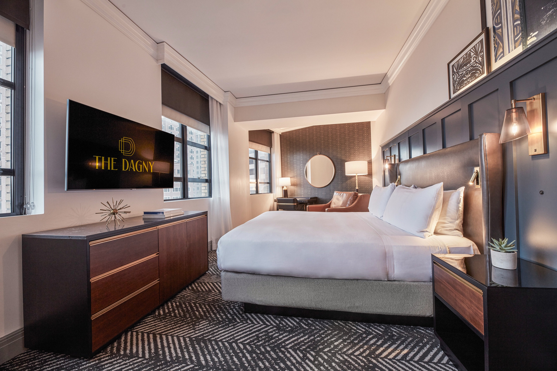 HBA Los Angeles renovated The Dagny Boston Hotel with guest rooms featuring wainscoting accents in handsome blue. This superior king room has build-in reading lights and woven and leather-like fabric wraps on the furniture.
