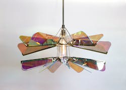 The undulating, multi-colored waves of the Arco chandelier cast beautiful shadows over the interior below.