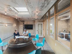 A duct that used to occupy the space was cut in half and a glass top placed upon it to create a one-of-a-kind conference table. A duct that used to occupy the space was cut in half and a glass top placed upon it to create a one-of-a-kind conference table.