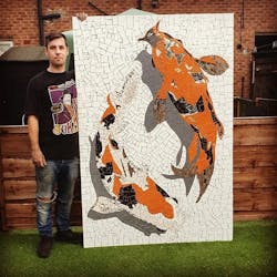 Artist David Arnott holds a mosaic.