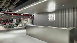 The PUBG STUDIOS&rsquo; front desk in Seoul, Korea, is decorated in galvanized steel and aluminum to create an industrial look. It is contrasted with the vibrant red and green found in PUBG&rsquo;s landscapes.