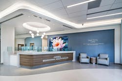 As patients and visitors enter the main lobby of the Cornell Behavioral Health Pavilion at Sarasota Memorial Hospital, they are welcomed by a soothing blue and gray color scheme, layered lighting, and artwork showcasing Florida's natural beauty. As patients and visitors enter the main lobby of the Cornell Behavioral Health Pavilion at Sarasota Memorial Hospital, they are welcomed by a soothing blue and gray color scheme, layered lighting, and artwork showcasing Florida's natural beauty.