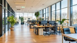 A contemporary office with large windows and daylight, wood floors, desks and chairs with several potted plants. A contemporary office with large windows and daylight, wood floors, desks and chairs with several potted plants.
