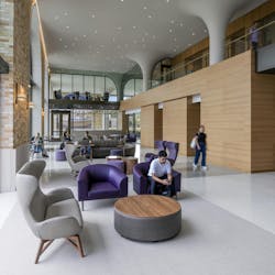 Large student hall with contemporary furniture, wood paneled walls and gray flooring. Large student hall with contemporary furniture, wood paneled walls and gray flooring.