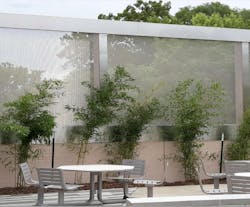 Outdoor courtyard area with woven metal fabric screens in the background. Outdoor courtyard area with woven metal fabric screens in the background.