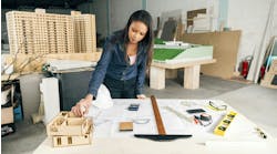 Interior designer considers a scaled 3D model of project Interior designer considers a scaled 3D model of project