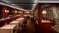 The dining room at Chez Fifi in New York City features luxurious mahogany paneling and soft, indirect lighting that maintains a cozy atmosphere. The dining room at Chez Fifi in New York City features luxurious mahogany paneling and soft, indirect lighting that maintains a cozy atmosphere.