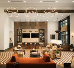 Multifamily communal space with patterned rust and brown carpet, rust colored settee, and neutral furnishings and finishes. Multifamily communal space with patterned rust and brown carpet, rust colored settee, and neutral furnishings and finishes.