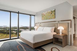 Curved edges on furnishings and rounded lampshades add to the idea of softness worked into the custom upholstered headboard design seen in guestrooms. Curved edges on furnishings and rounded lampshades add to the idea of softness worked into the custom upholstered headboard design seen in guestrooms.