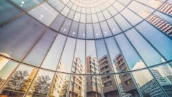 Reflection of apartment buildings in curved, glass facade of modern office tower. Reflection of apartment buildings in curved, glass facade of modern office tower.