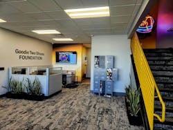 The lobby of the Good Two Shoes Foundation office features lockers filled with sneakers and the company's name displayed on the wall. The lobby of the Good Two Shoes Foundation office features lockers filled with sneakers and the company's name displayed on the wall.