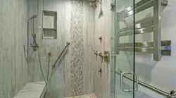 Walk-in/roll-in shower in bathroom with grab bars and removable shower head