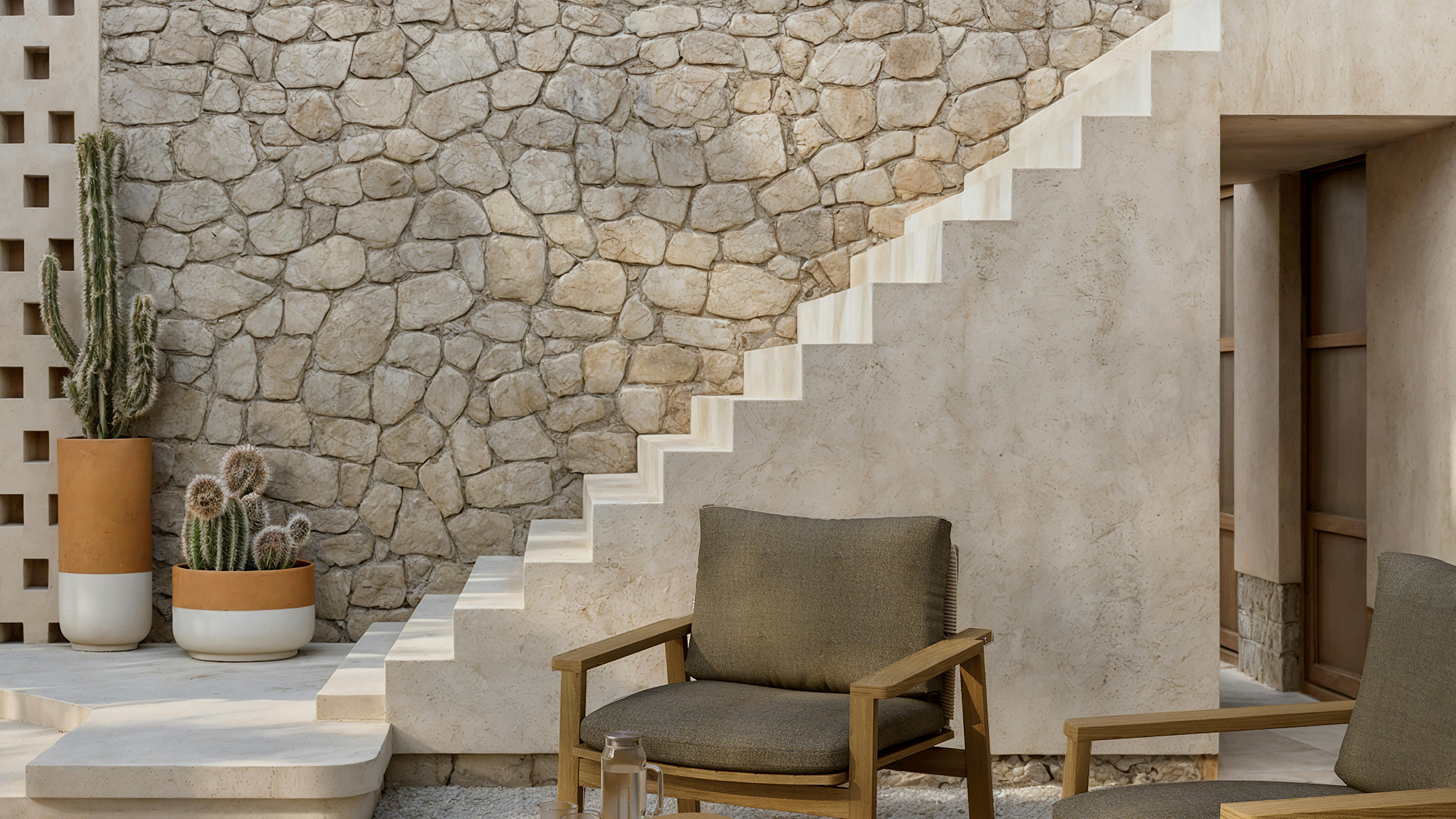 Denk armchairs feature teak wood frames and woven rope or fabric backrests.