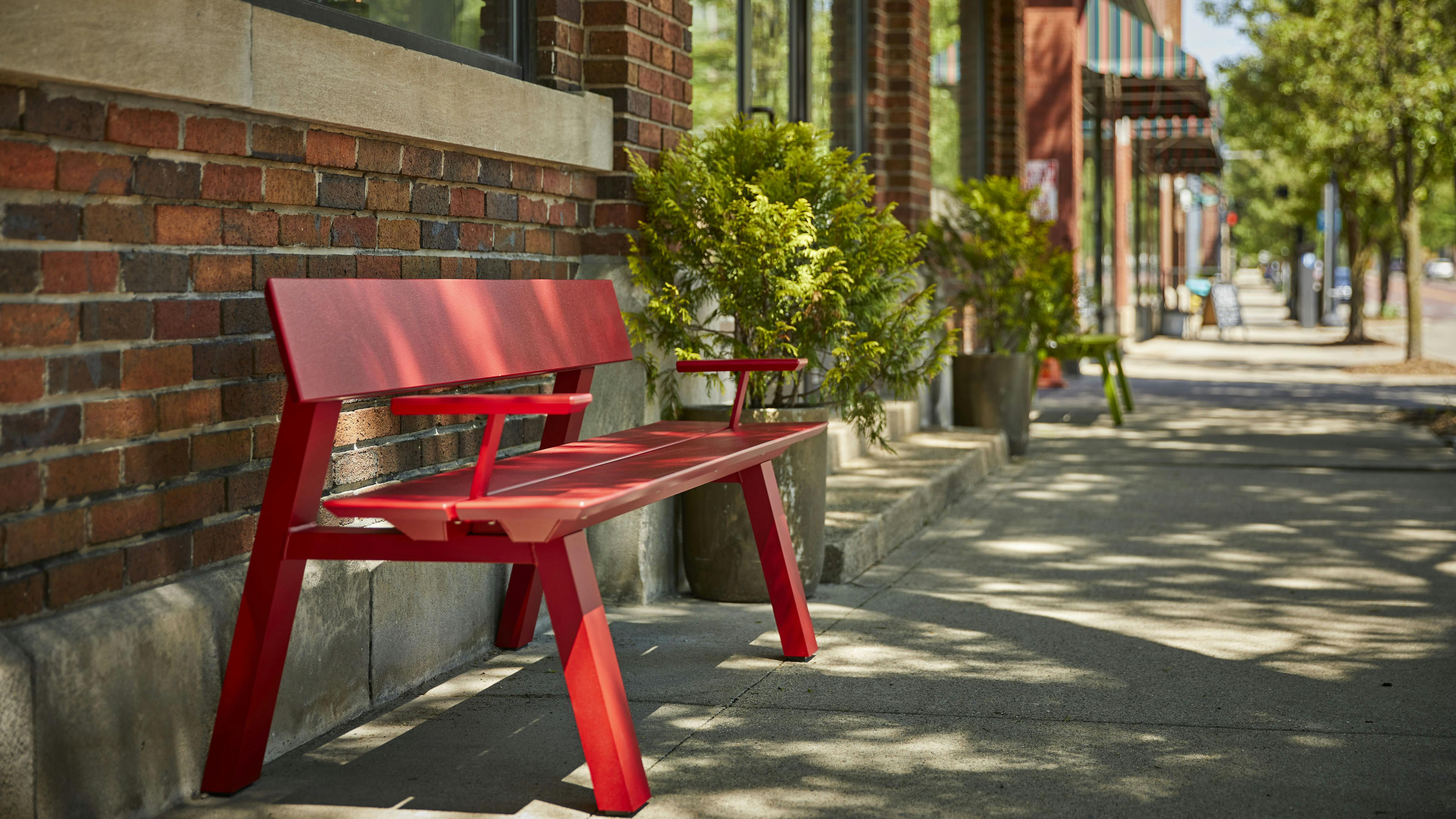 The Glide Bench, shown in red, creates a place to rest along a sidewalk.