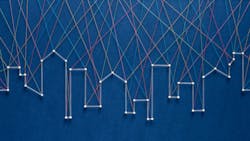 Thread art strung together with pins in the shape of a city skyline against a navy blue background. Thread art strung together with pins in the shape of a city skyline against a navy blue background.