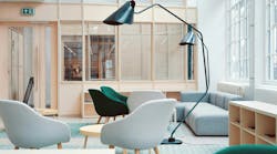 Zoned workspace for collaboration with light-colored furnishings, natural wood tones, and windows Zoned workspace for collaboration with light-colored furnishings, natural wood tones, and windows