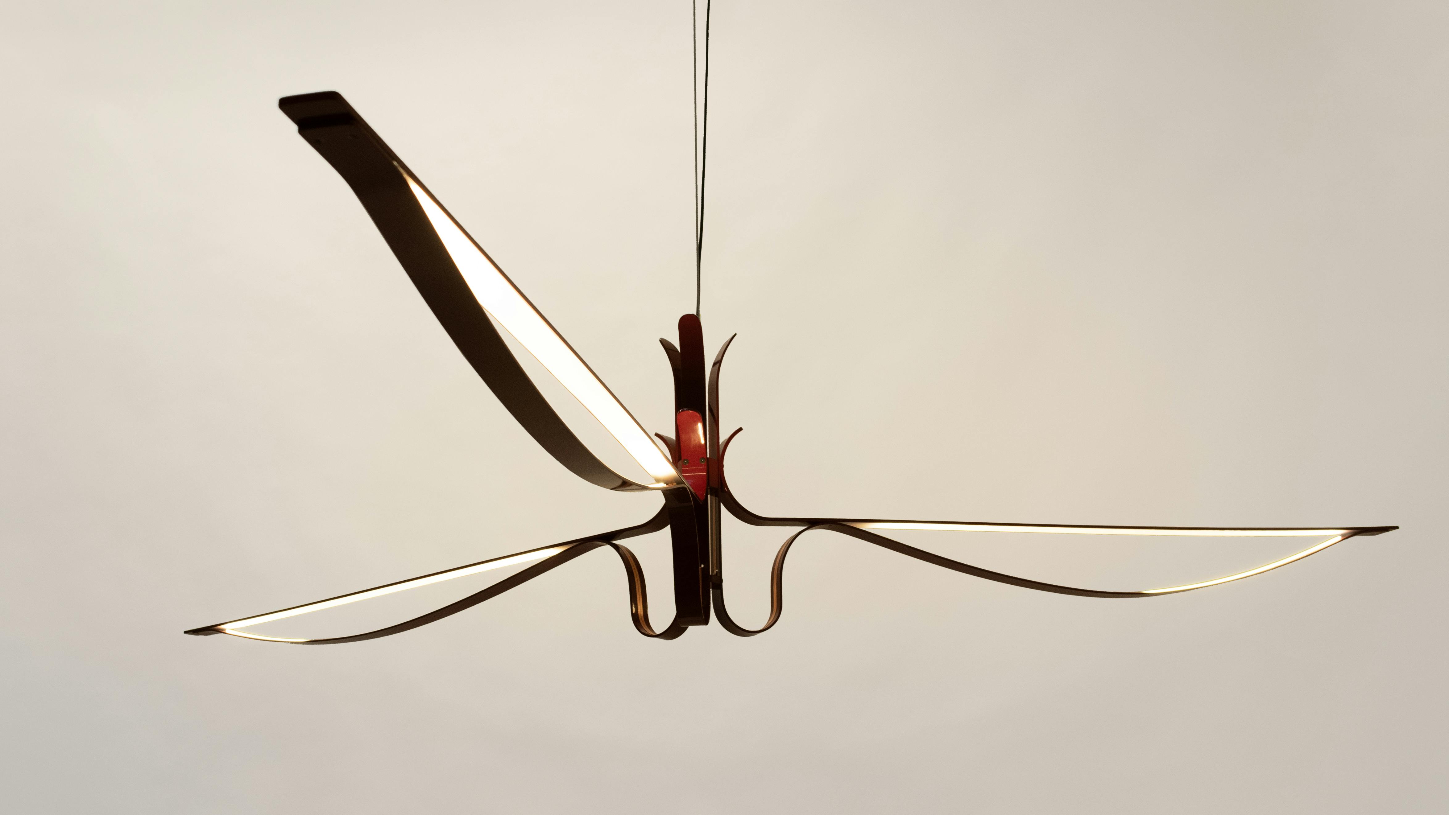 ARCHER pendant features three sweeping arms and evokes a sense of weightlessness.