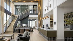 High-end hotel lobby with grand staircase, lounge furniture, and reception desk with warm tones and gold details. High-end hotel lobby with grand staircase, lounge furniture, and reception desk with warm tones and gold details.