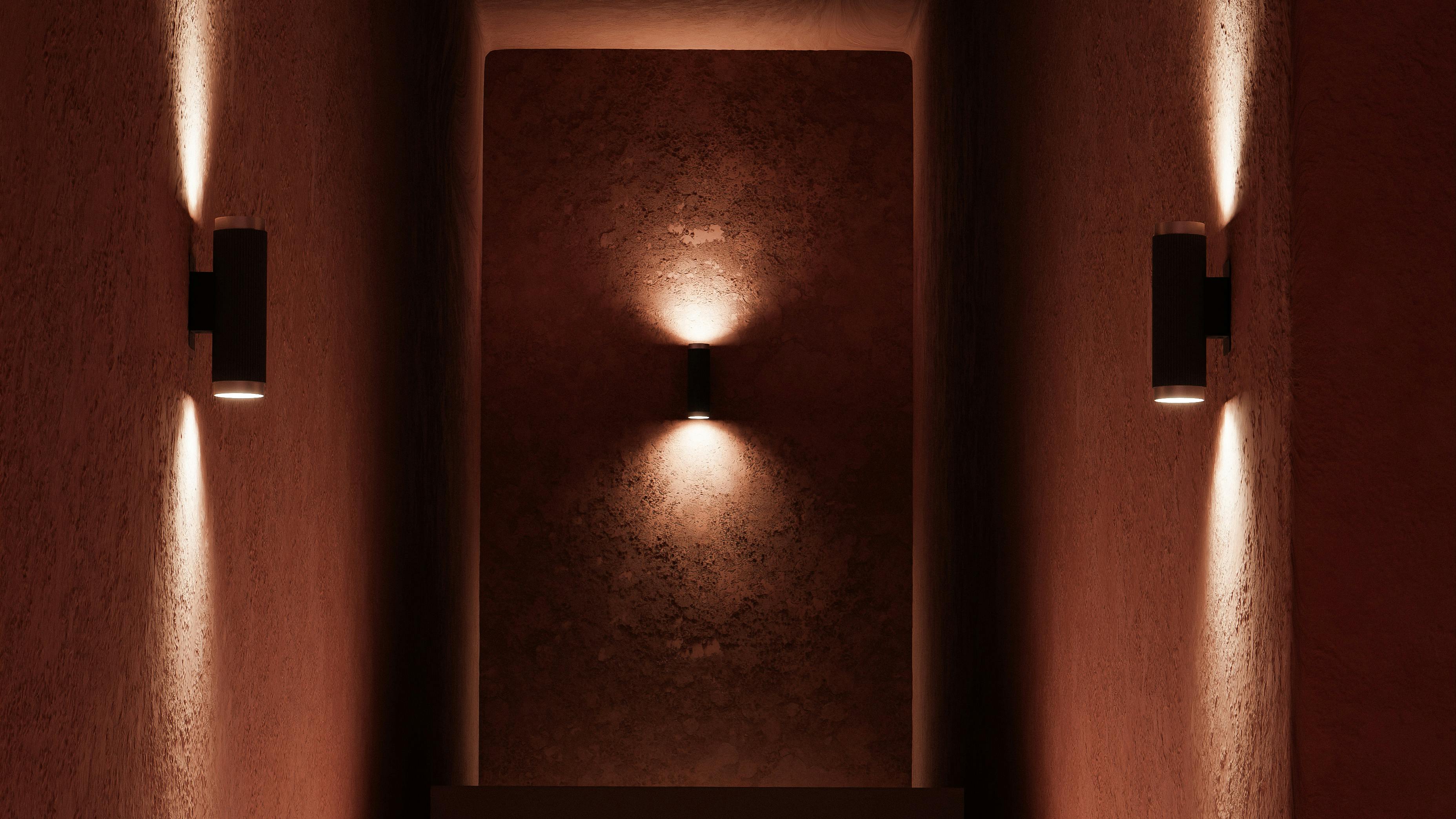 The NuDrop Sconce 2.5 is a wall-mounted LED luminaire installed in a hallway.