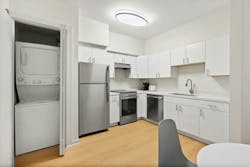 Minimalist kitchen with built-in storage space for stacked washer and dryer. Minimalist kitchen with built-in storage space for stacked washer and dryer.