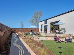 Enclosed outdoor area for employees and dogs, with landscaping and furniture Enclosed outdoor area for employees and dogs, with landscaping and furniture