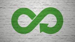 Green infinity symbol with recycling arrows overlaid against white brick wall. Green infinity symbol with recycling arrows overlaid against white brick wall.