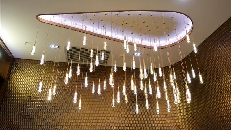 A round LED chandelier illuminates the ceiling and surround walls.