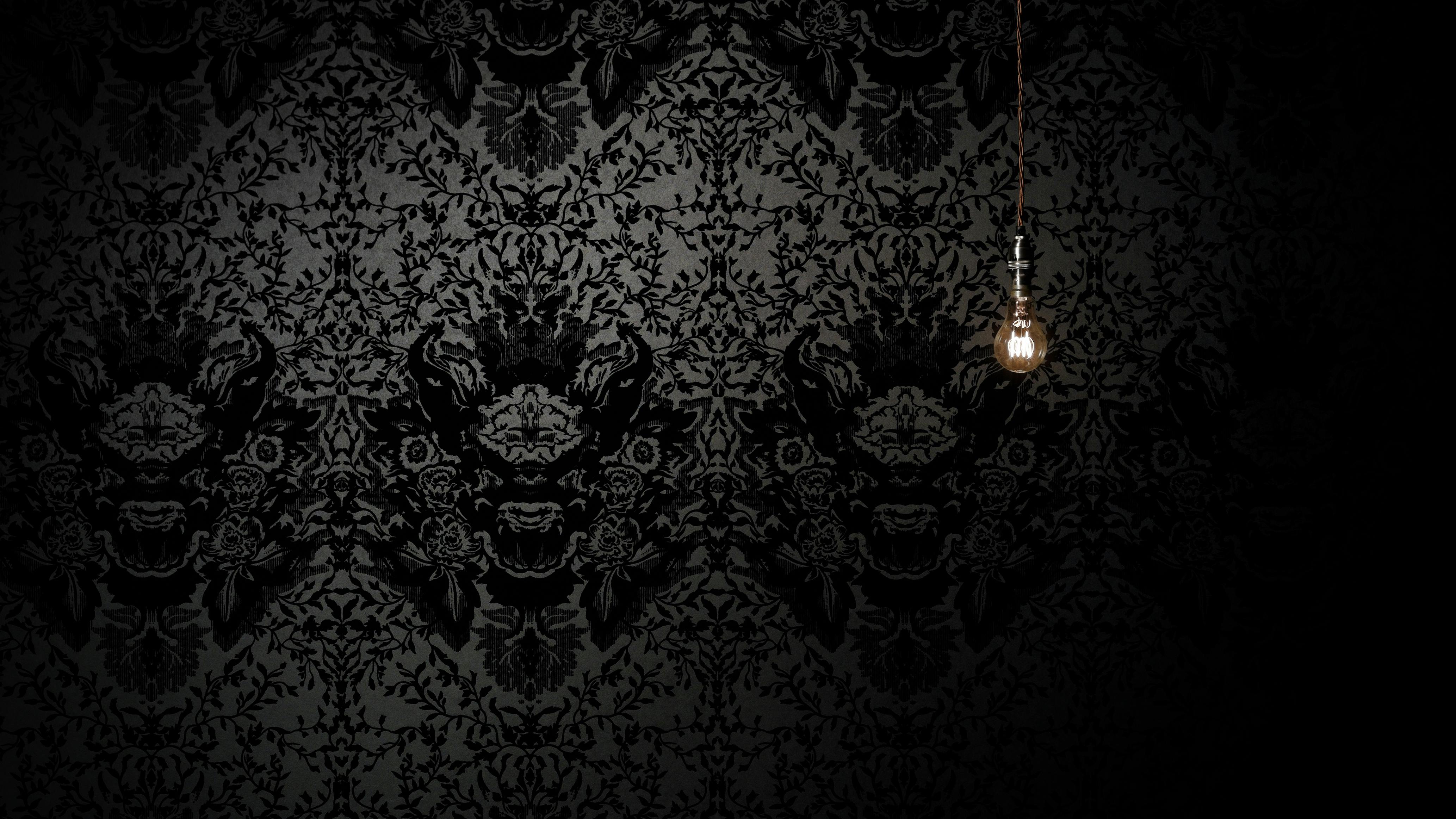 A small, dim light illuminates Timorous Beasties' Devil Damask Wallpaper.