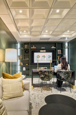 Work zone with dark green built-in shelves, a central worktable with exotic patterned chairs, soft lounge seating, and subtle patterned accessories creating a quiet, inviting setting. Work zone with dark green built-in shelves, a central worktable with exotic patterned chairs, soft lounge seating, and subtle patterned accessories creating a quiet, inviting setting.