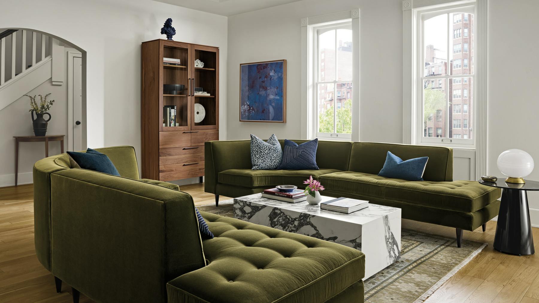 Marble-look coffee table surrounded by plush green seating