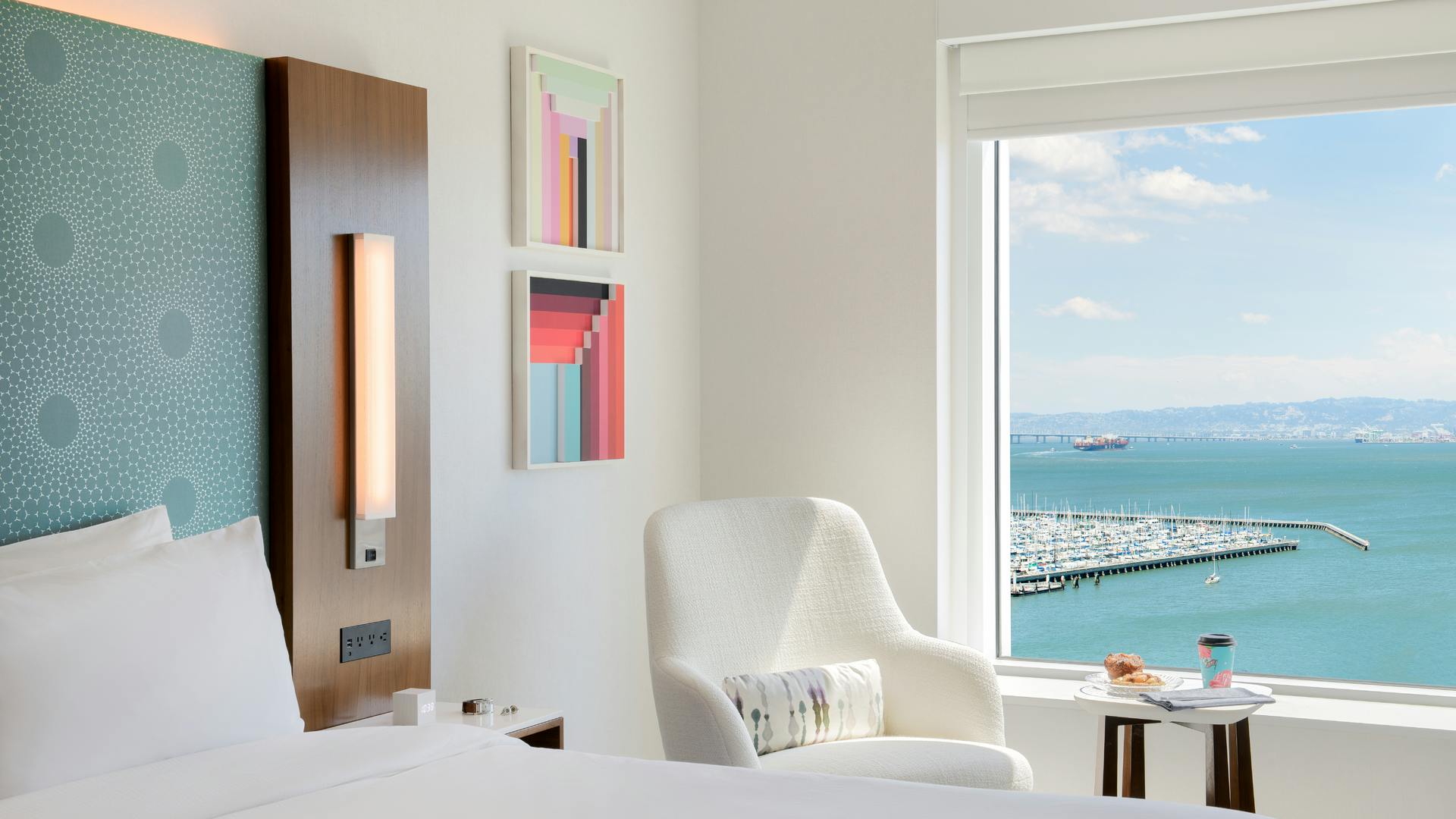Guest room in the Luma Hotel with views of the bay through window in background.