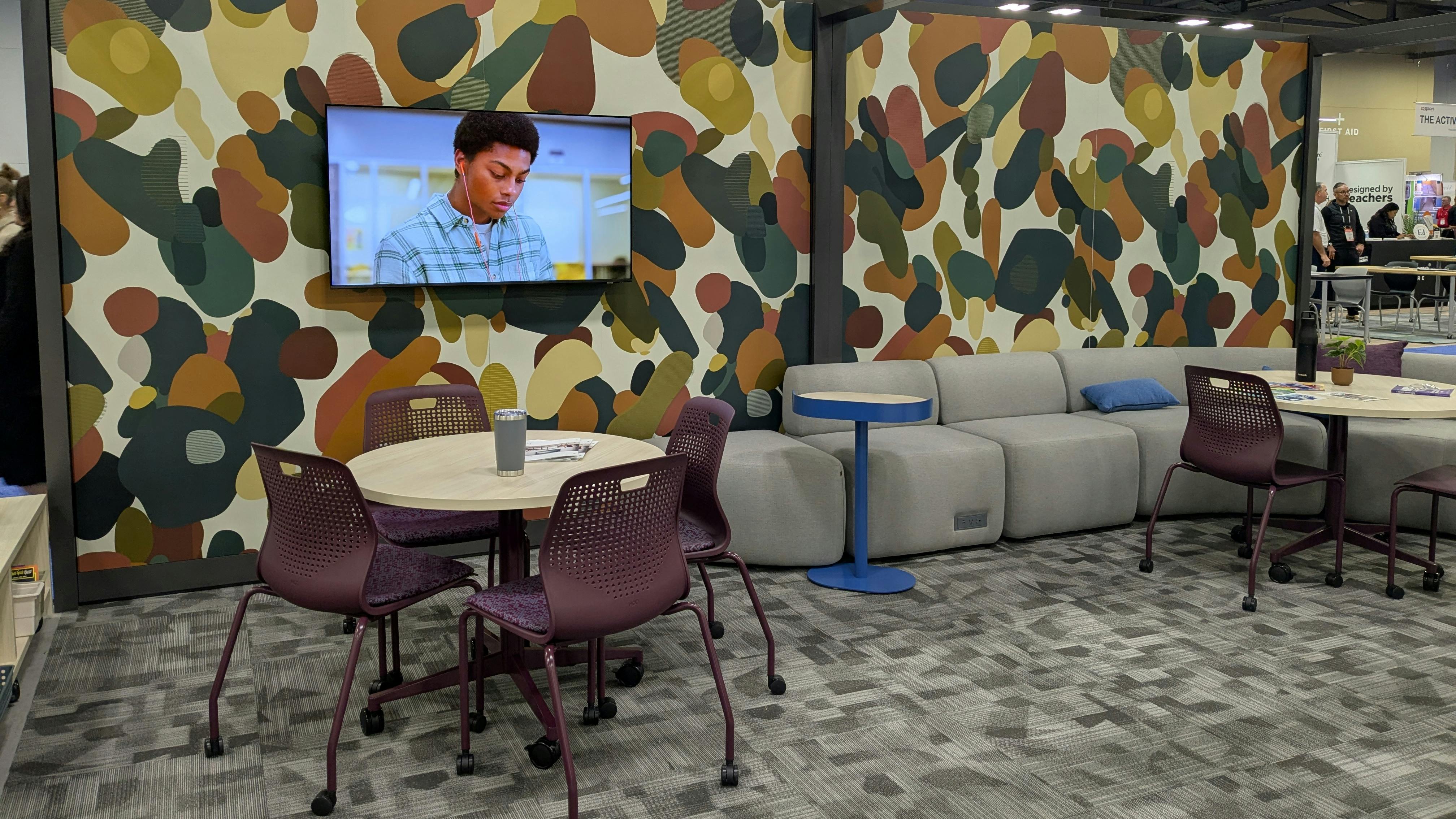 HON exhibit features a sample staff amenity space with wallcovering and chairs in desaturated colors.