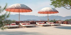 This 12-foot parasol features hand-tufted blossoms. Two parasols are opened to shade outdoor lounge chairs. This 12-foot parasol features hand-tufted blossoms. Two parasols are opened to shade outdoor lounge chairs.