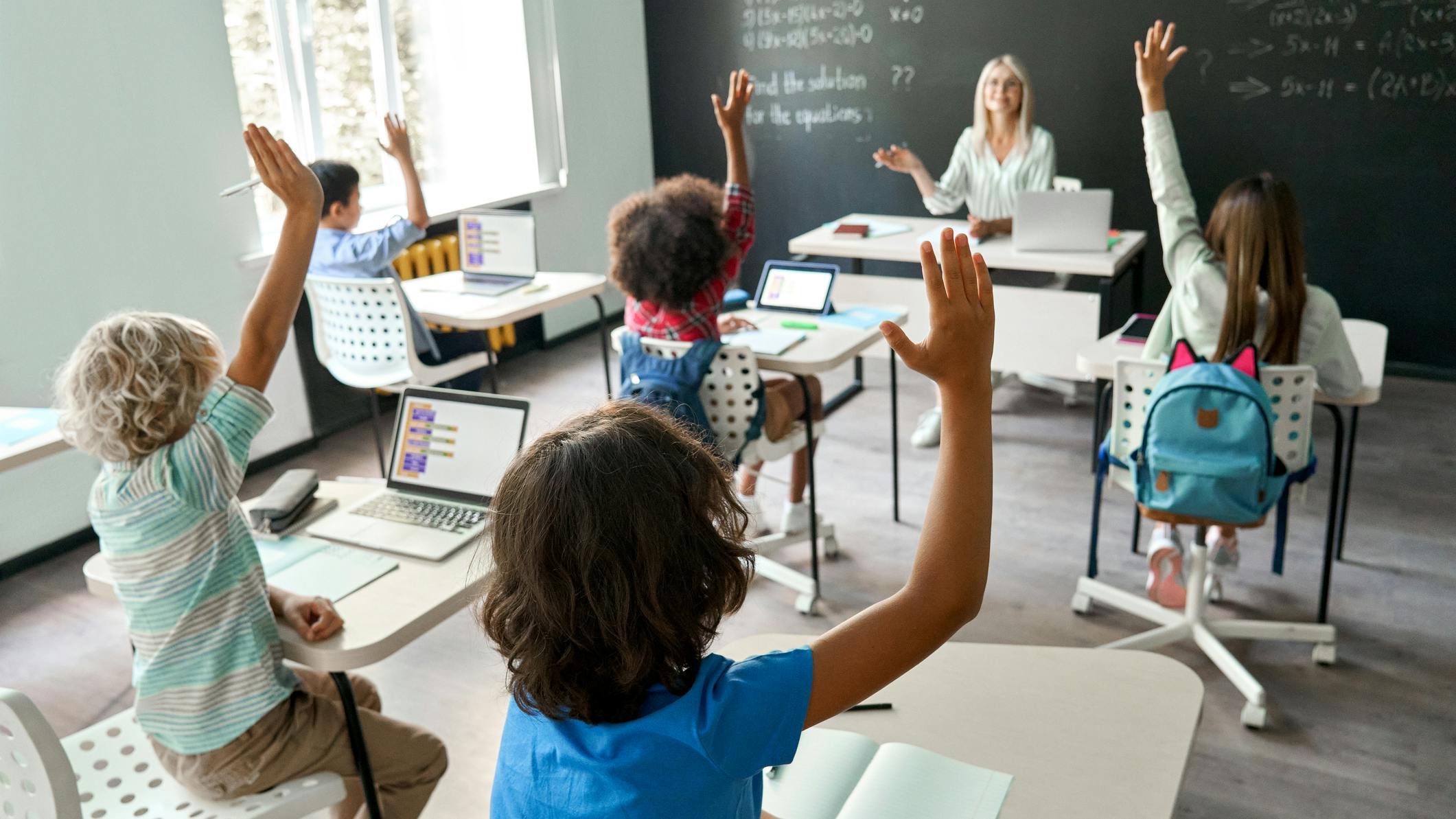 Female teacher leads math class in contemporary elementary school environment