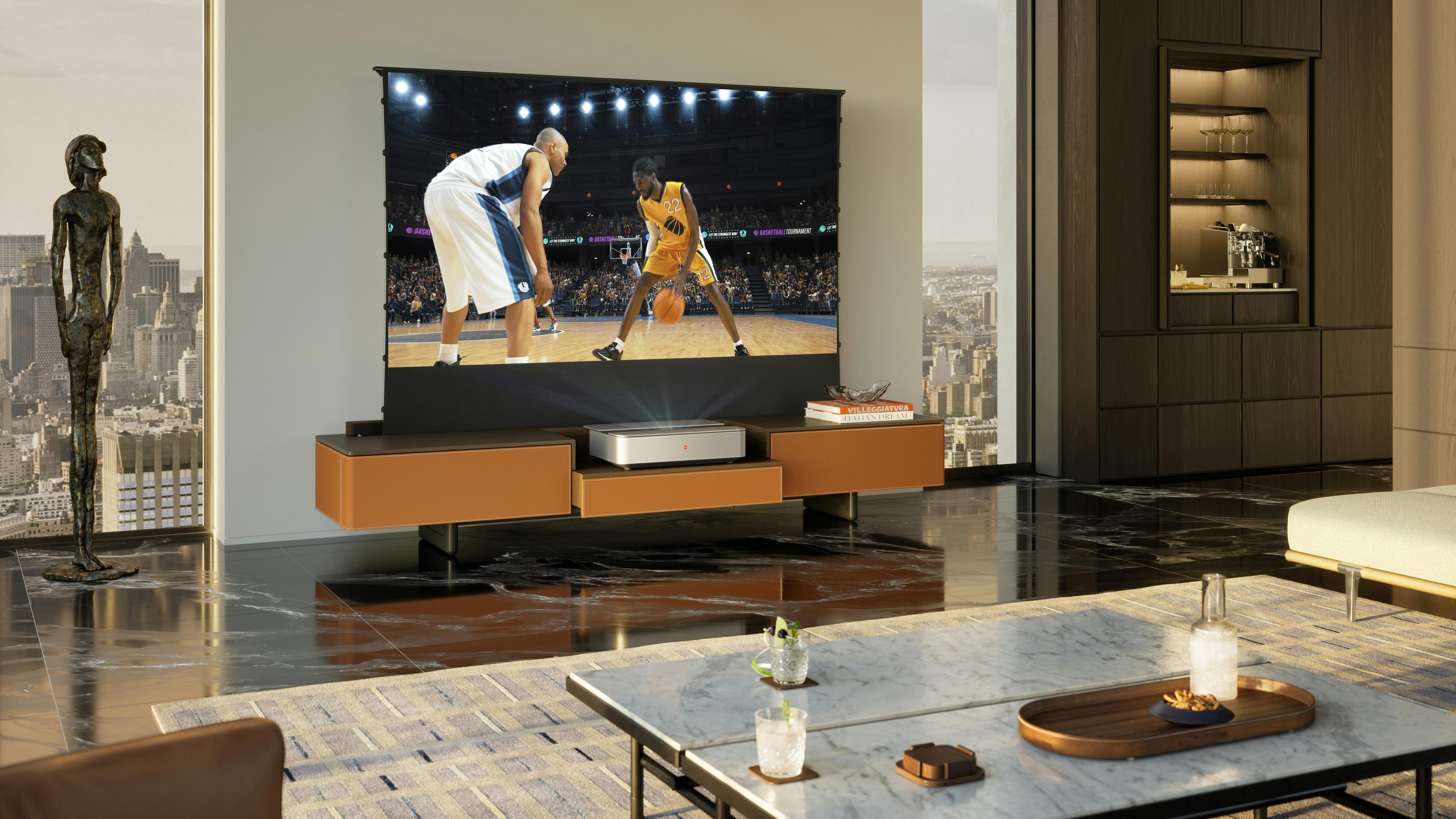 The Poltrona Frau x Leica Fidelio Multimedia Cabinet makes any living or hospitality space a gathering hub. The cabinet is shown in a living room with a TV set on top.