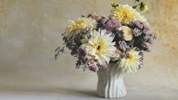 The Barely Cinched vase with a floral arrangement of purple and white flowers. The Barely Cinched vase with a floral arrangement of purple and white flowers.