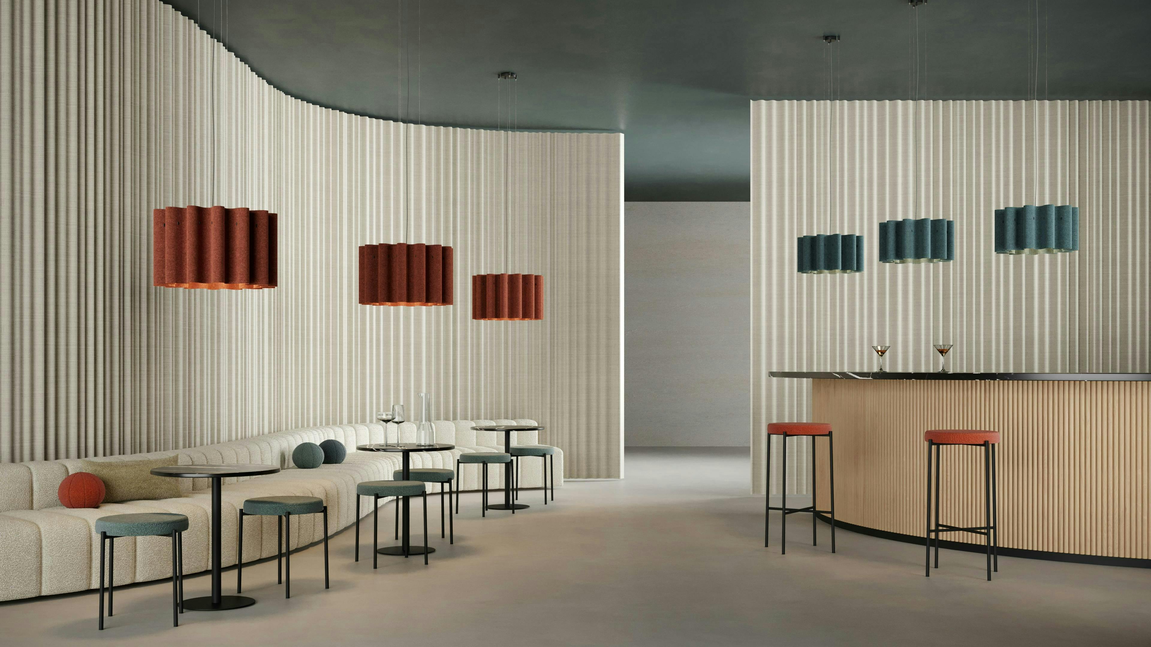 Curved booth seating with tables and chair with acoustic drapery and lighting.