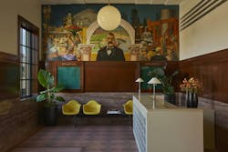 The Lighthouse lobby highlights a large mural depicting the early days of Venice, California, and is accompanied by yellow seating, dark wood trim and mouldings, and neutral stone flooring and surfaces. The Lighthouse lobby highlights a large mural depicting the early days of Venice, California, and is accompanied by yellow seating, dark wood trim and mouldings, and neutral stone flooring and surfaces.