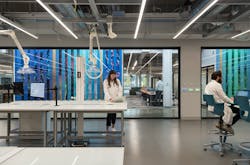 Workplace interior with bold colors, natural materials, and biophilic elements integrated across lab and office environments. Workplace interior with bold colors, natural materials, and biophilic elements integrated across lab and office environments.