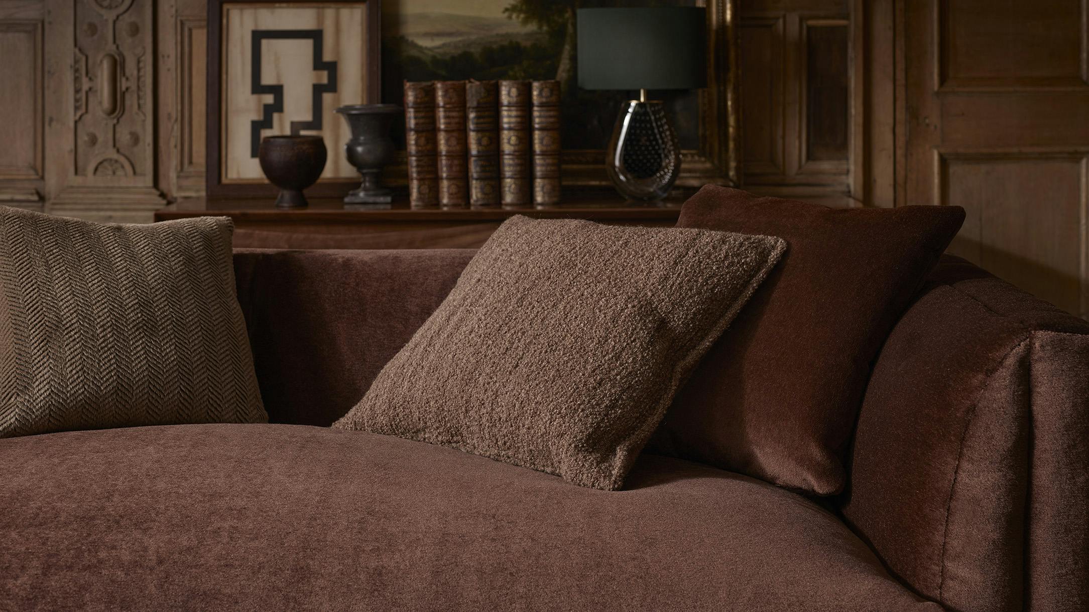 The Antoinette upholstery fabric, shown in Oxblood, is accented by pillows with fabrics Onde Boucl&eacute; Brindle in Rosewood and Camelot in Bronzite.